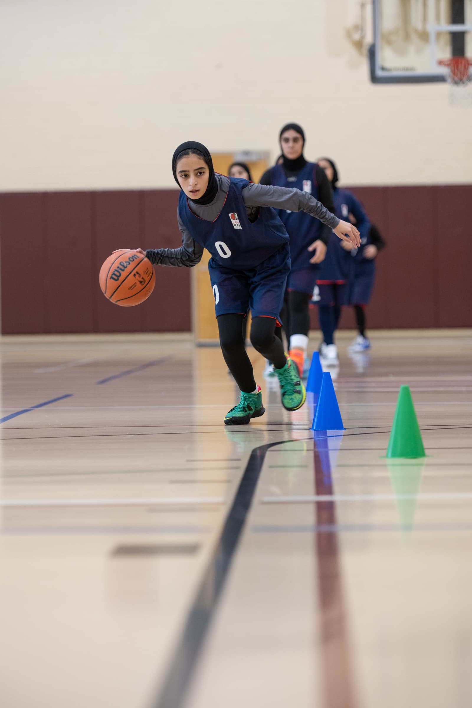 UAE woman basketball player dribbling basketball