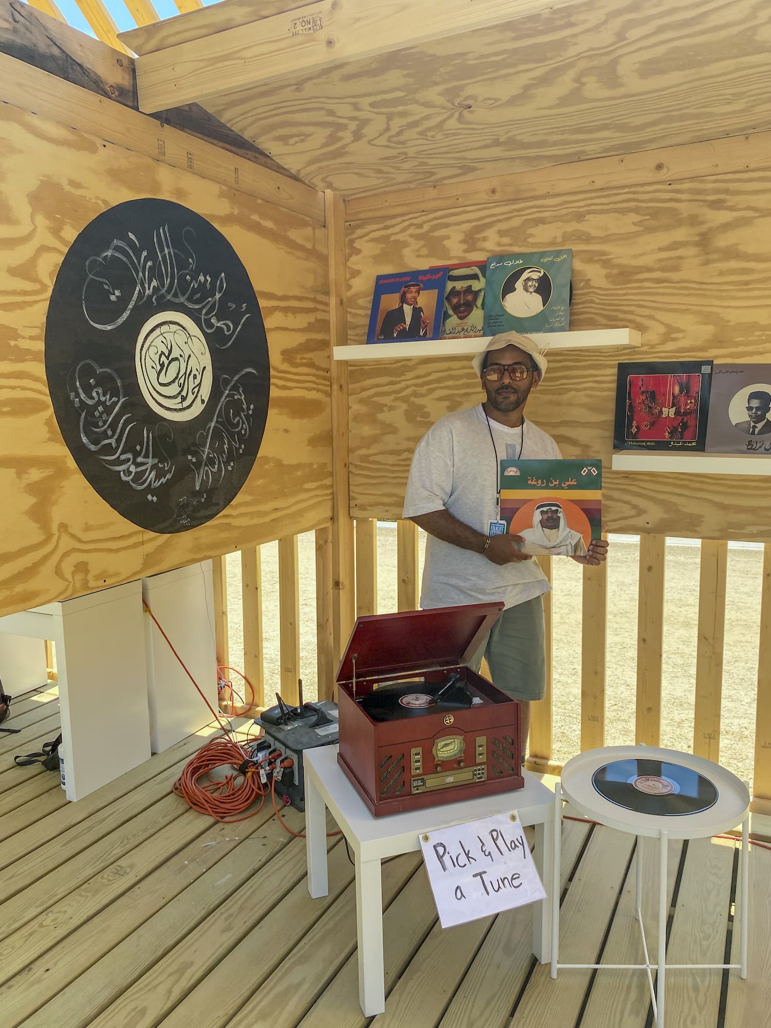 Mohamed Jneibi standing with a vinyl record collection