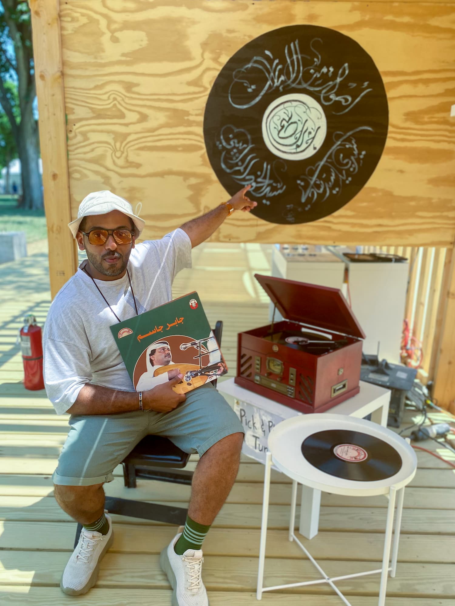 Mohamed Jneibi sitting next to an old vinyl record player