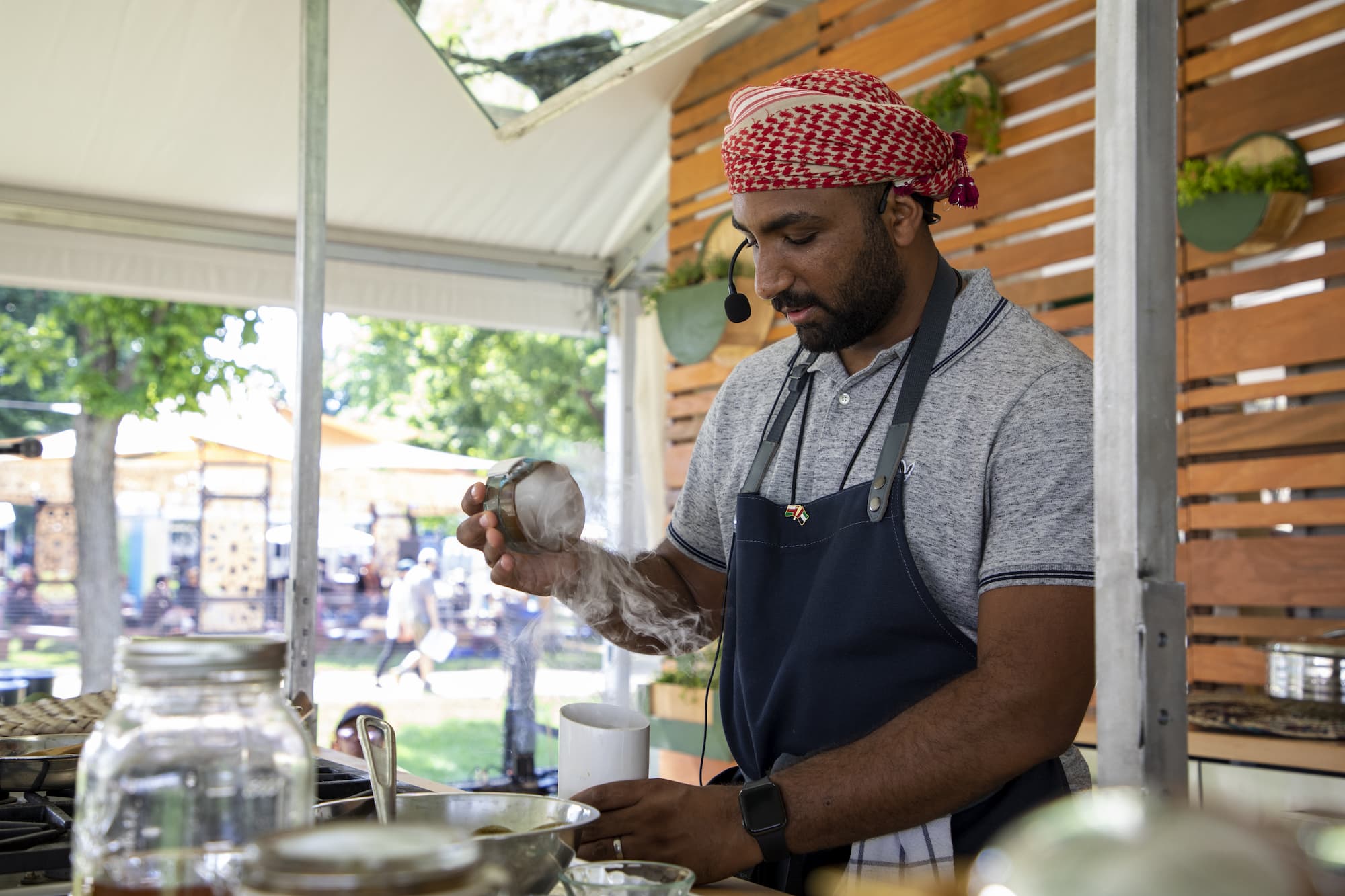 Mommin Al Rawahi cooking on a stovetop on an outdoor stage