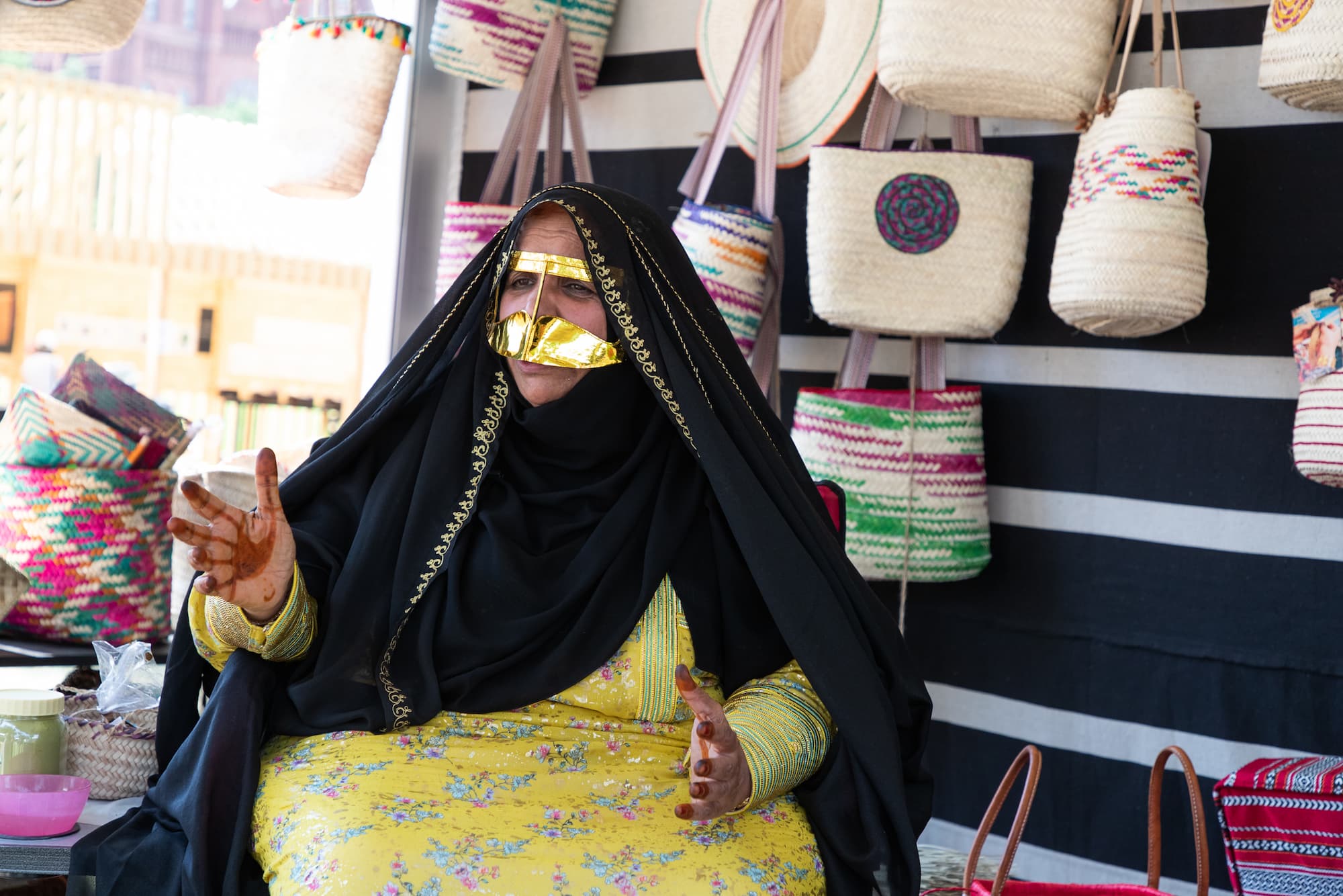 Shamma Muhair Ghanim Al Qubaisi sitting in front of a display of handmade baskets